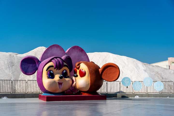 Two oversized Mickey Mouse are placed in front of Budai Salt Fields for tourists to take photos